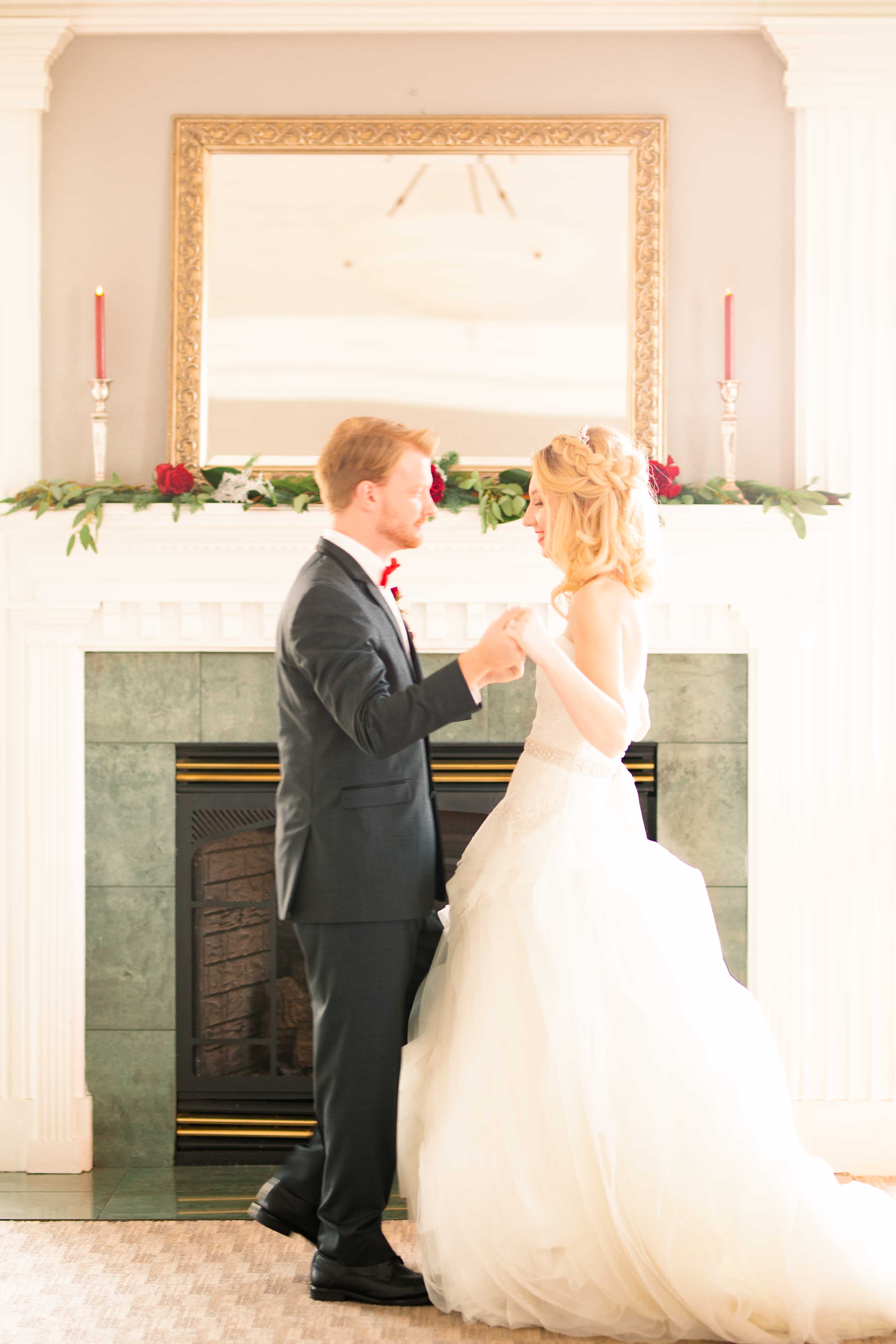 winter wedding couple dance in front of fireplace